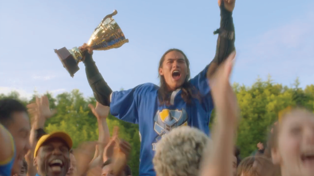 BooBoo Stewart as his character Jay from Disney's Descendants in his jousting uniform holding a trophy in a screenshot