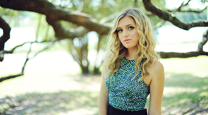 Image of singer Samantha LaPorta standing outside by a tree