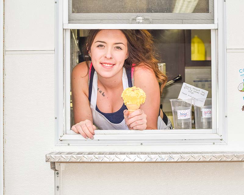 Teen girl working at an ice cream stand in the summer