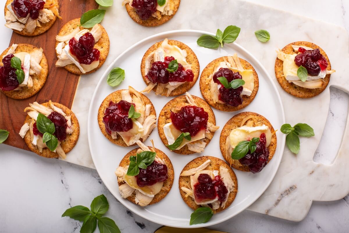 Shutterstock: Party appetizers with roasted turkey, brie and cranberry sauce on crackers for Thanksgiving
