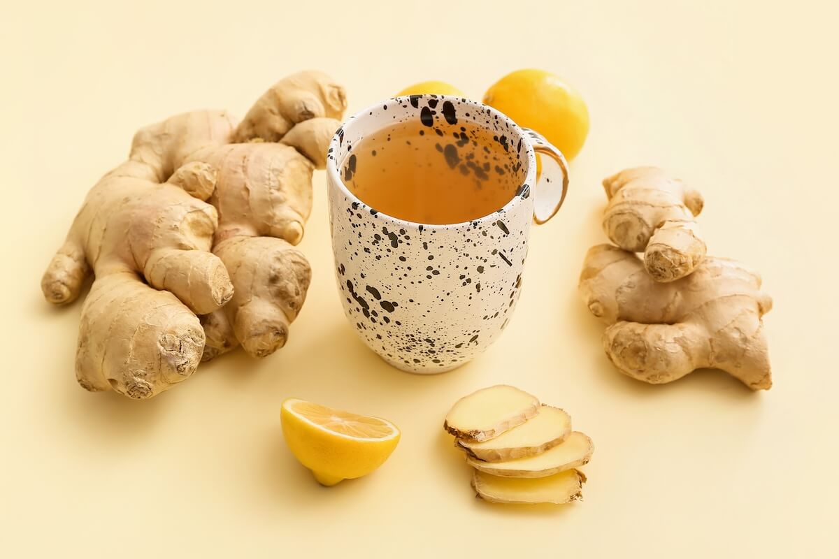 Shutterstock: Cup of tea with ginger and lemons on color background