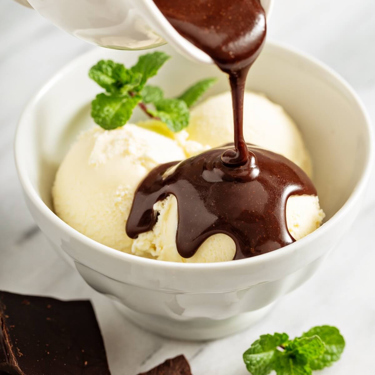 Shutterstock: Pouring chocolate sauce on scoops of vanilla ice cream