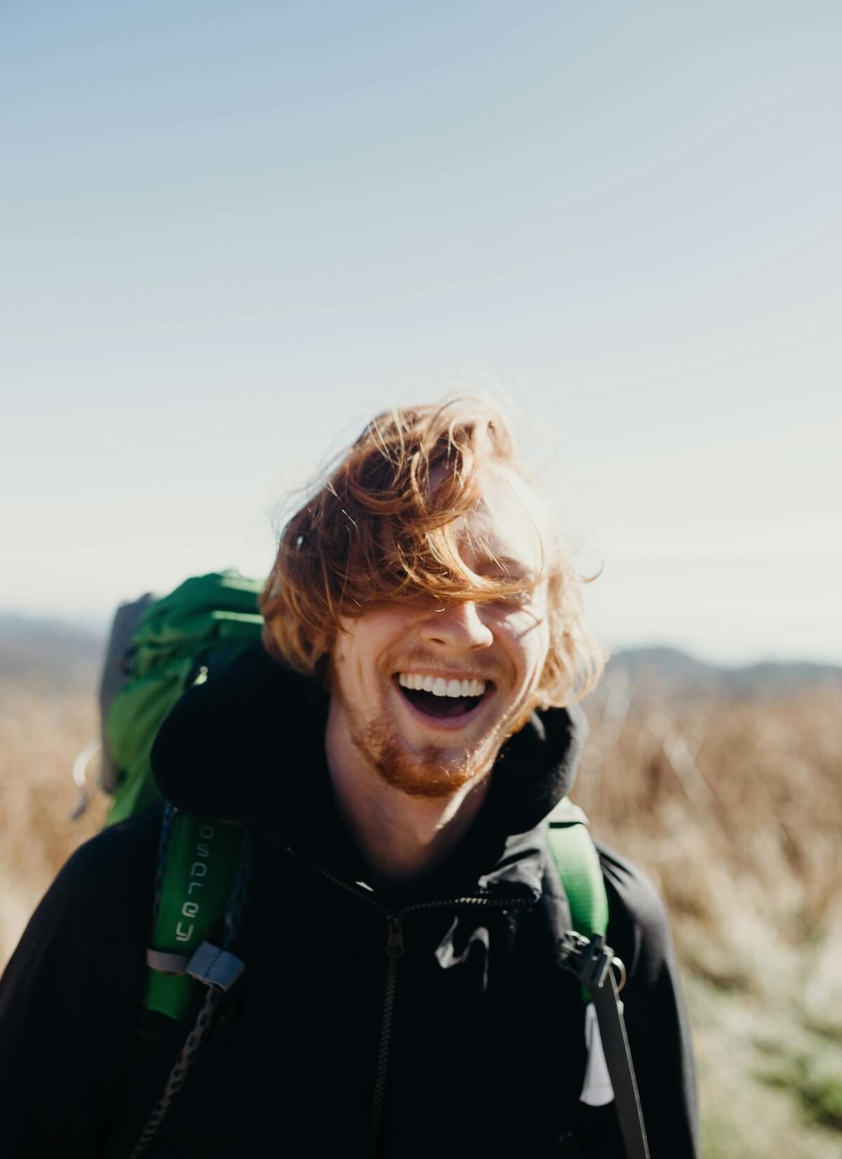 Unsplash: Man backpacking and happy by Mike Baker