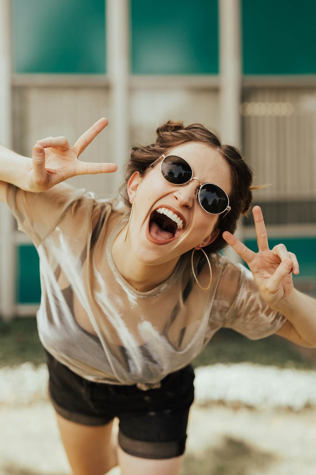 Unsplash: Woman making peace signs with hands by brooke cagle