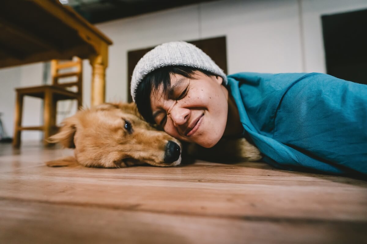 Shutterstock: person takes a selfie with ayear golden retriever. The dog is licking its owner's face. People and fun playing together Looking happily at the camera at home