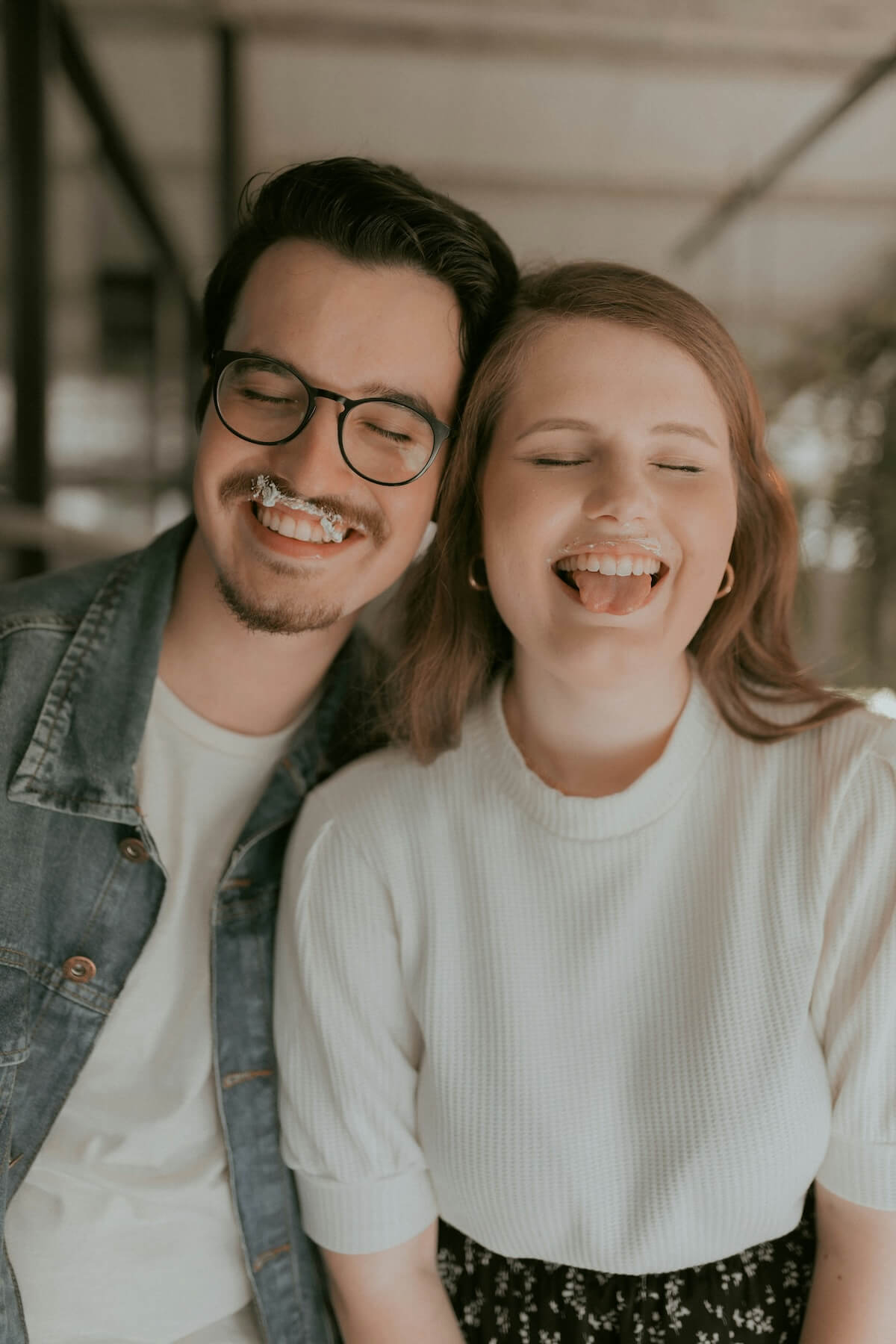 Unsplash: couple with frosting on mouths laughing by Alexander Mass