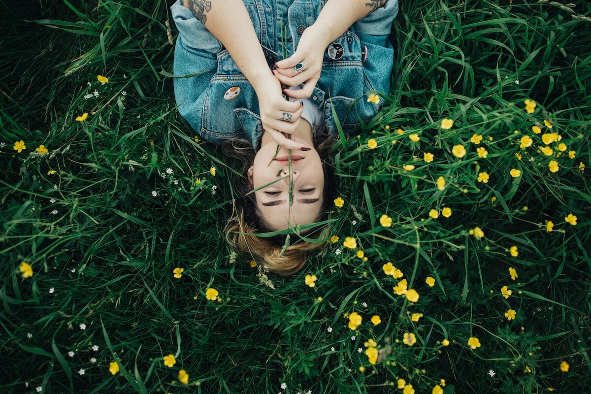 Unsplash: Woman laying back in spring flowers by Wes Hicks
