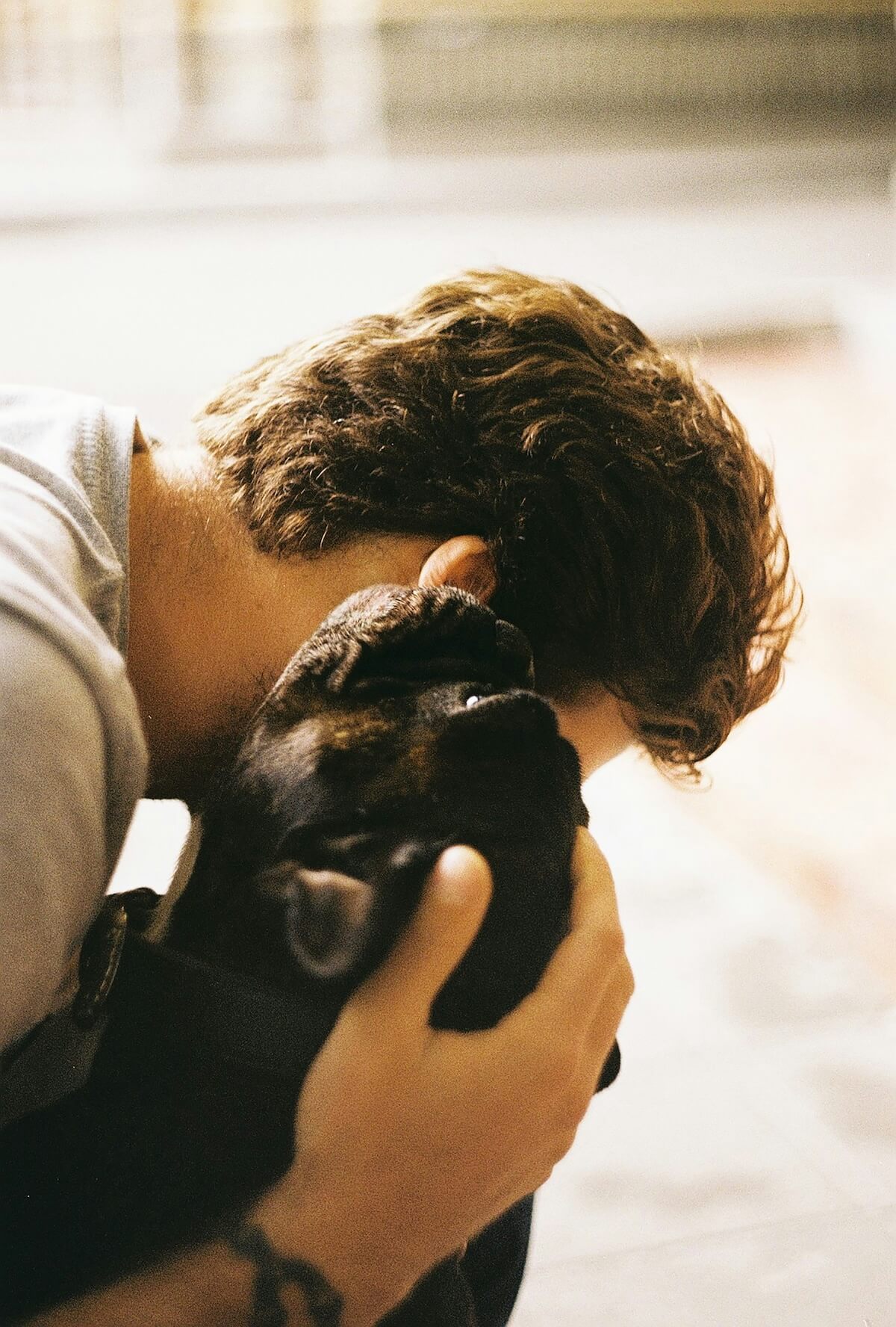 Unsplash: Man snuggling french bulldog by Dasha Urvachova