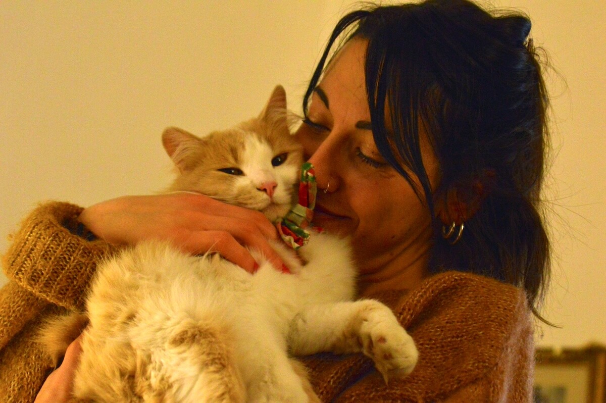 Unsplash: Woman snuggling cat by Alessandro Armignacco