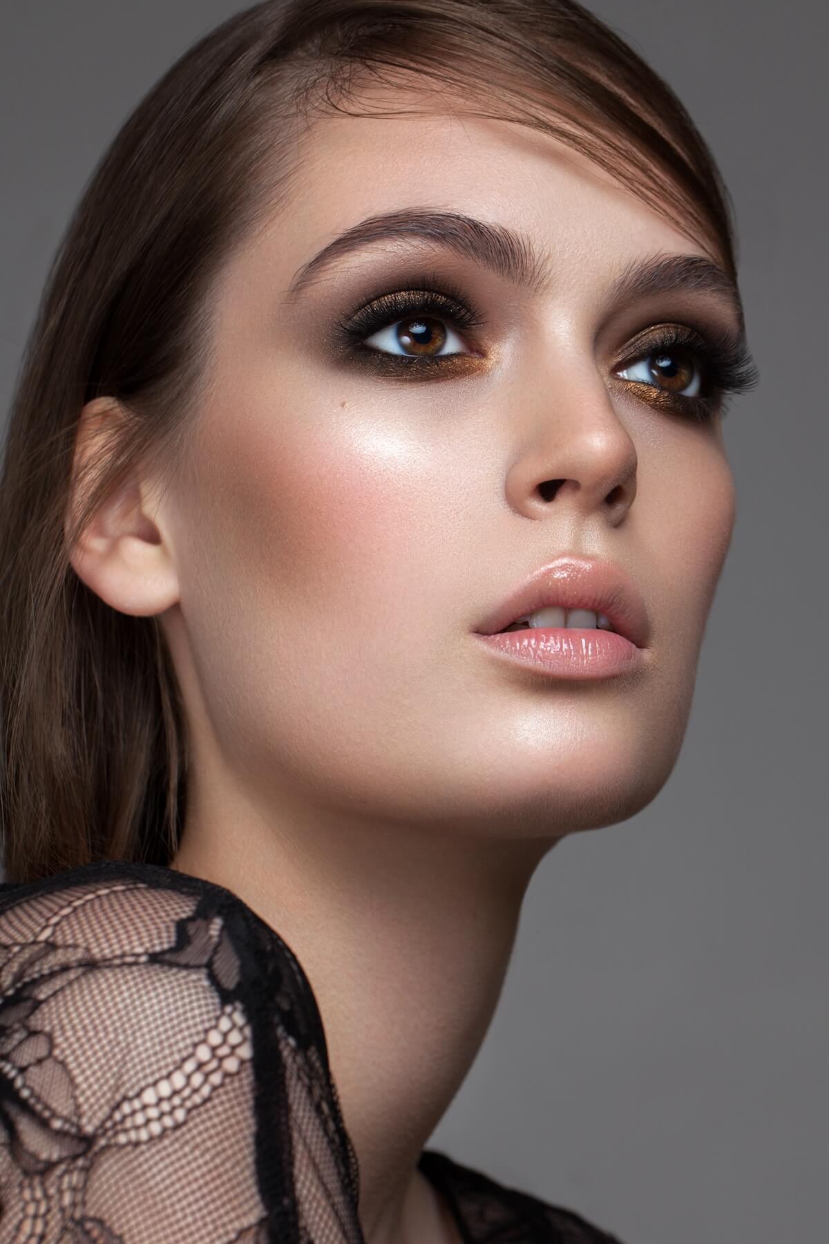 Shutterstock: Photo of young beautiful brunette girl with professional makeup, trendy gold eyeshadows, nude lipstick and natural hair.