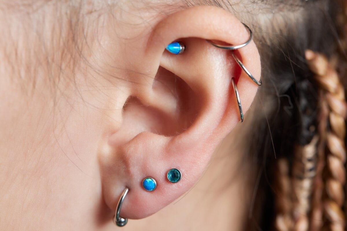 Shutterstock: piercings on an ear. Conch and helix piercings close up.