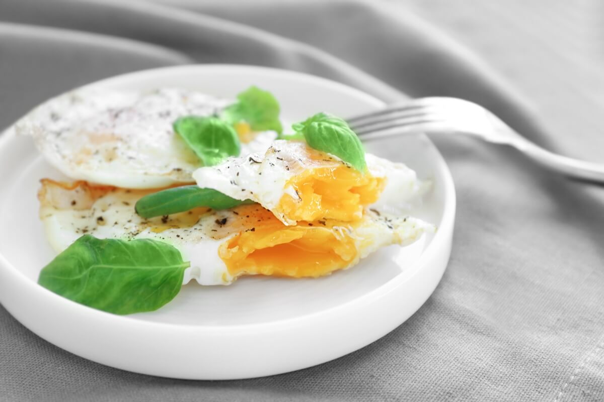 Plate with delicious over hard fried eggs on tablecloth