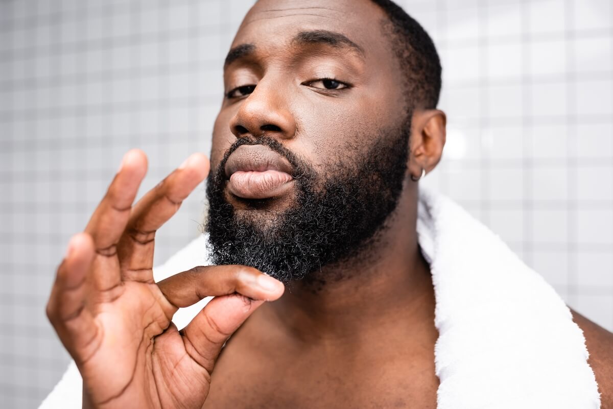 Shutterstock: portrait of afro-american man using cure for strengthening beard growth