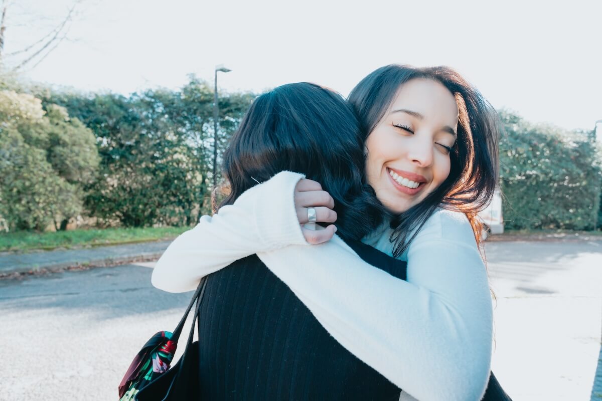 Shutterstock: Two university student friends embracing each other happy after meeting again at campus after holiday. Hug lovely concept. Study and learn together concept. Back to school and class.