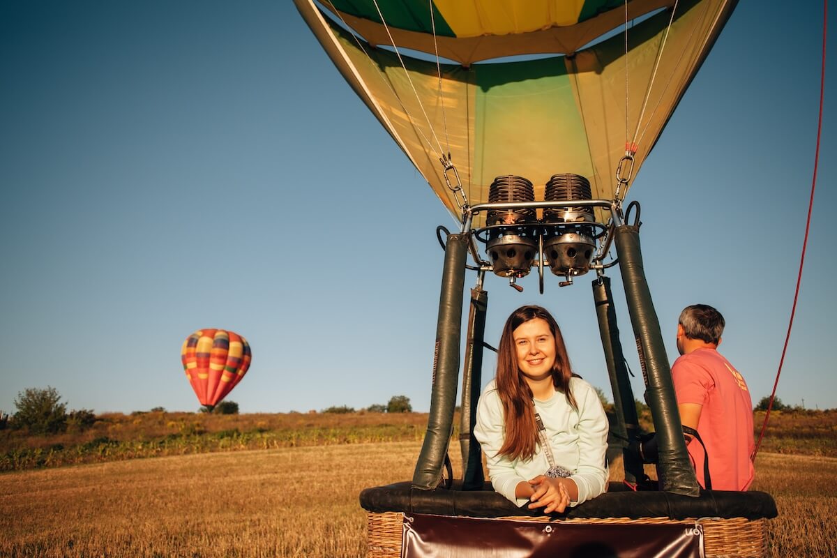 Shutterstock: Woman smiling during hot air balloon flight over countryside, enjoying adventure and breathtaking views