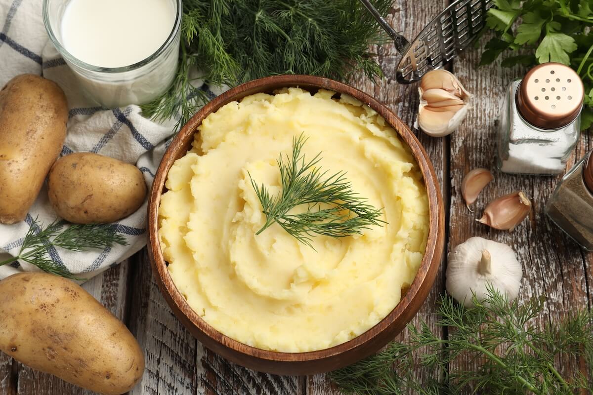 Shutterstock: Delicious mashed potato with dill served on wooden table, flat lay