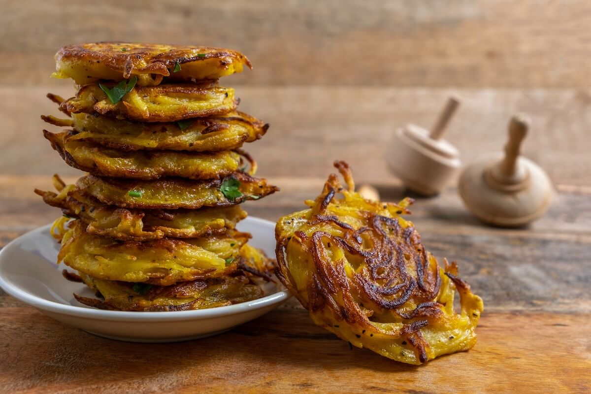 Shutterstock: Traditional Hanukkah latkes over wooden background. Potato fritters for Jewish holiday Hanukkah.
