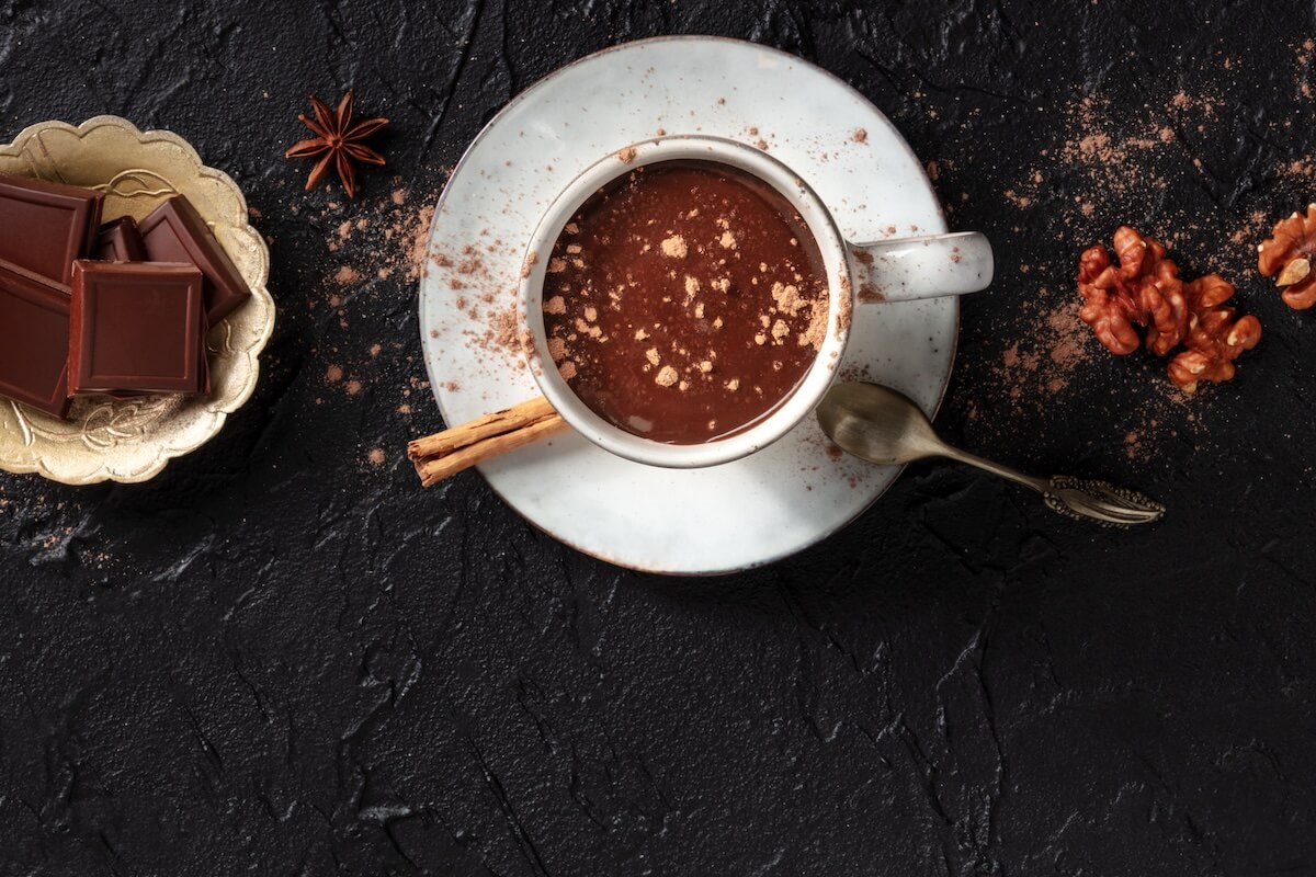 Shutterstock: Hot chocolate with cinnamon, nuts, and copy space, shot from above on a black background