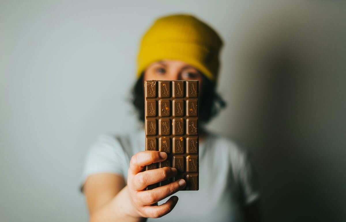 Unsplash: woman holding up chocolate bar by Tamas Pap
