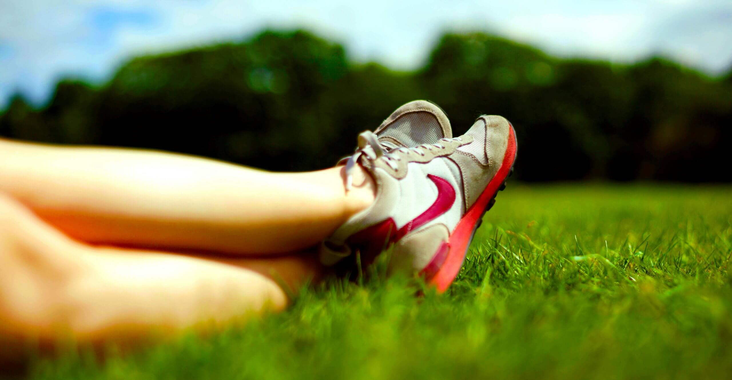Unsplash: Feet with tennis shoes over grass by paul bryan