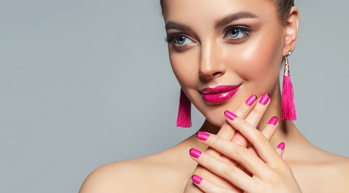 Shutterstock: Beautiful model girl with pink fuchsia manicure on nails . Fashion makeup and cosmetics . Large earrings tassels jewelry Magenta color .