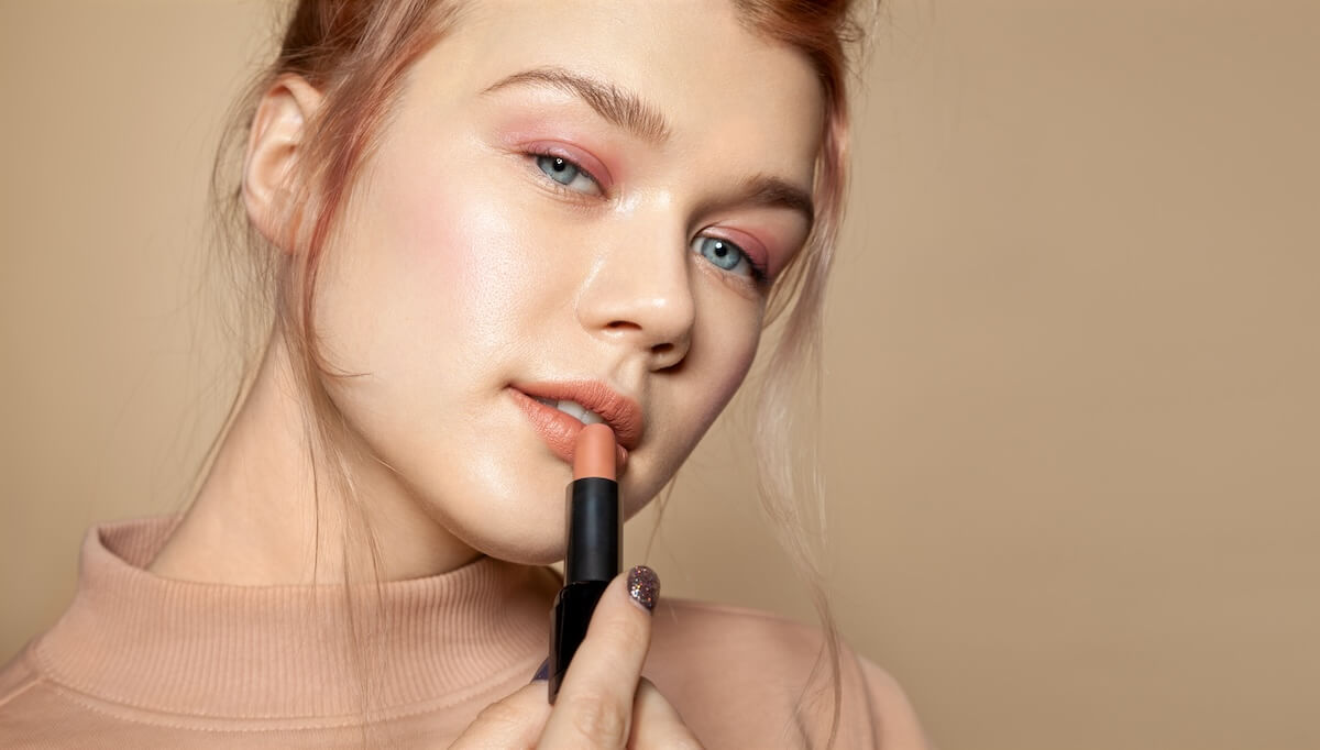 Shutterstock: Close up of female face with beautiful features. Pretty sensual girl dyeing lips with nude lipstick. Sophisticated girlie with amazing blue eyes and delicate make-up. Cosmetics beauty concept