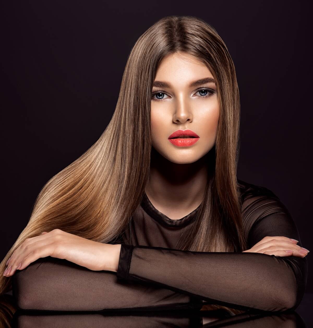 Shutterstock: Woman with beauty long brown hair. Beautiful model with long straight hair. Model with a smokey makeup. Pretty woman with orange color lipstick on lips.