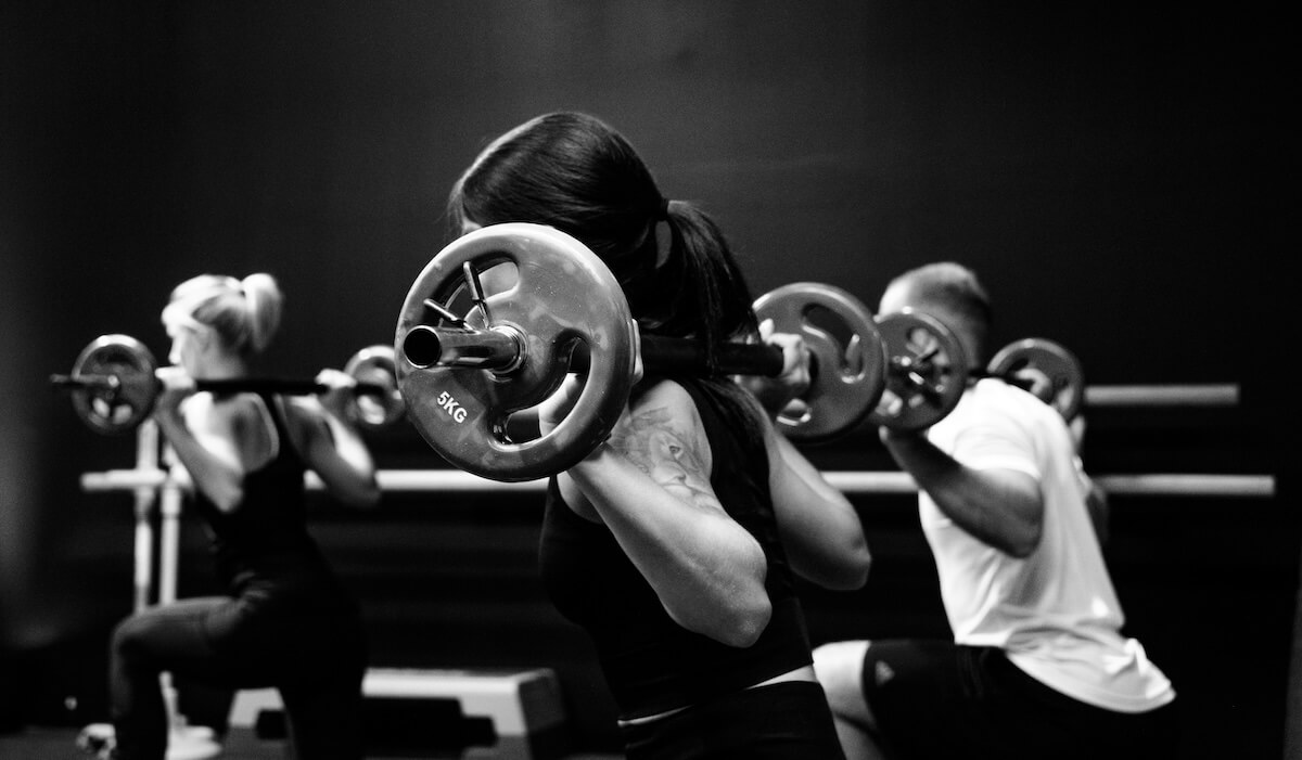 Unsplash: Group workout lifting weights by Sven Mieke