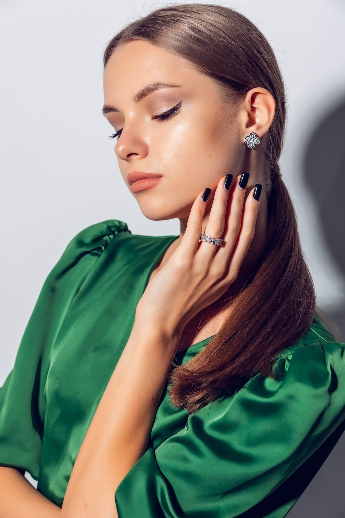 Shutterstock: Photo of a beautiful girl with blond hair in a green dress with jewelry in a photo studio on a white background