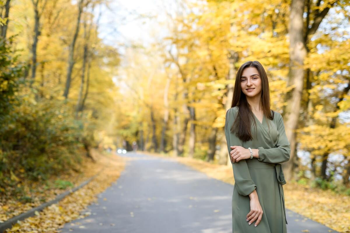 Shutterstock: Female portrait. Brunette woman portrait in autumn park wearing olive dress