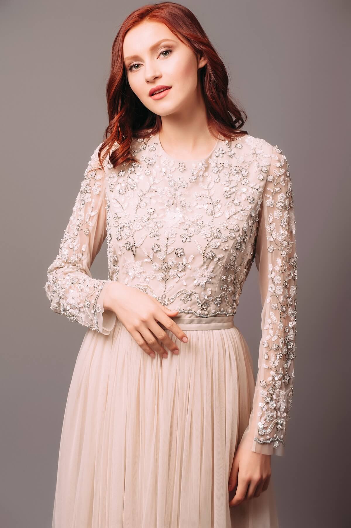 Shutterstock: Ivory long sleeve maxi wedding dress. Transparent bodice with floral embroidery and tulle skirt. Sensual portrait of happy redhead bride. Trendy bridal hairstyle and makeup. Bridesmaid's outlook