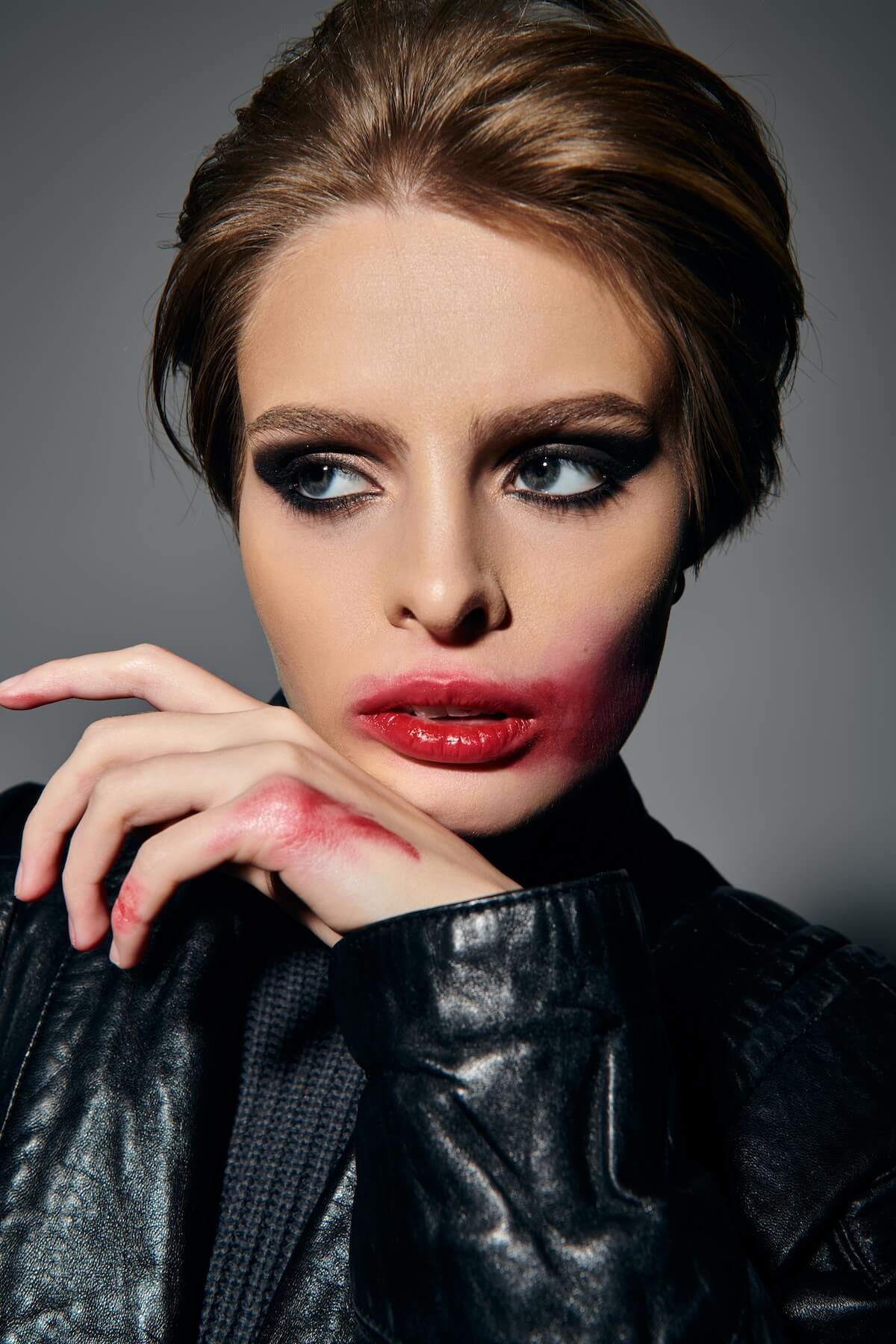 Shutterstock: A woman with dark makeup and a leather jacket poses against a grey backdrop.