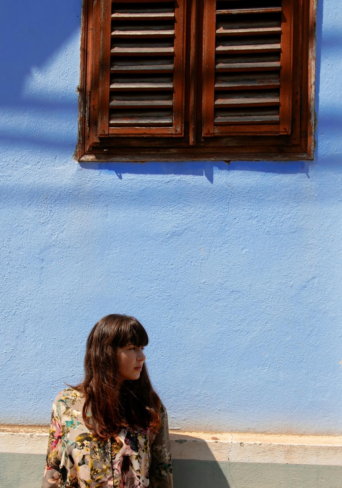 Unsplash: Woman with bang haircut under window by emmeline