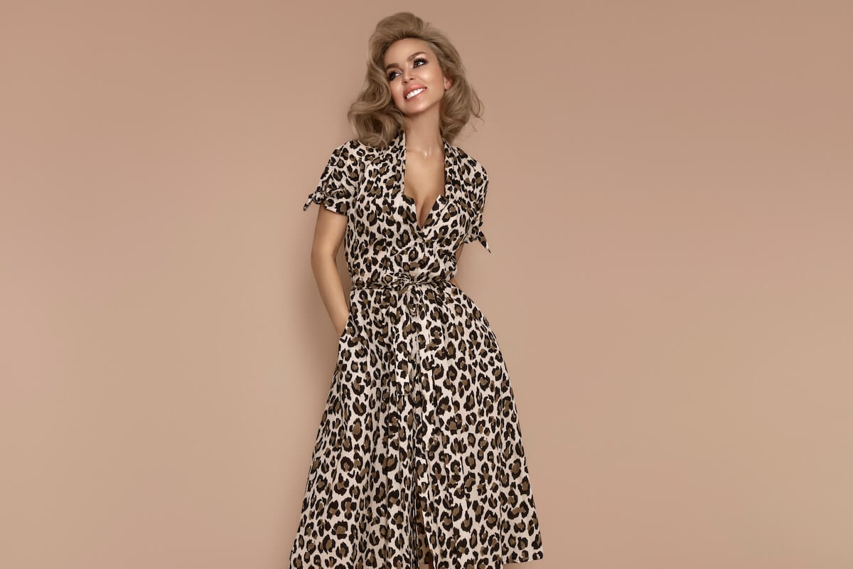 Shutterstock: Stylish female model wearing a fashionable leopard-print dress is posing on a beige background in the studio.