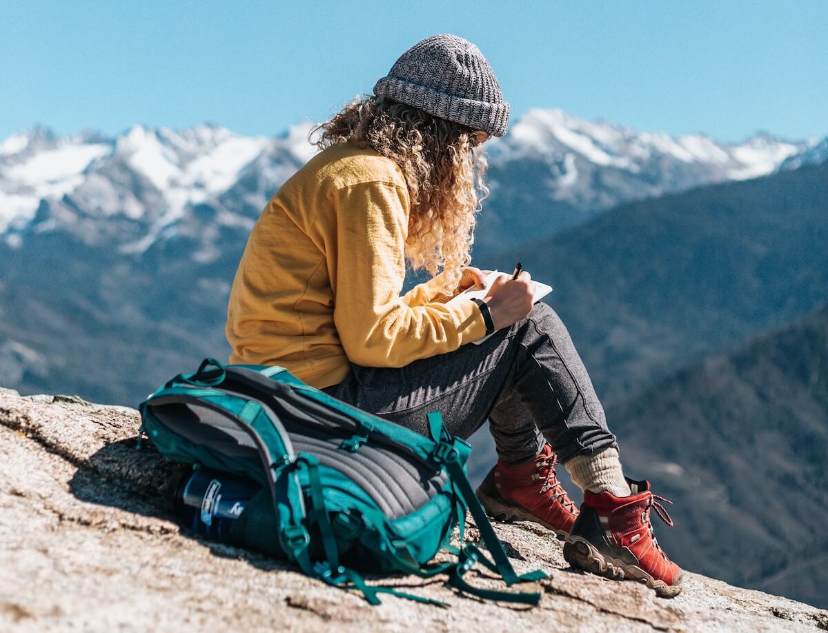 woman-hiking-mountains-writing-journal