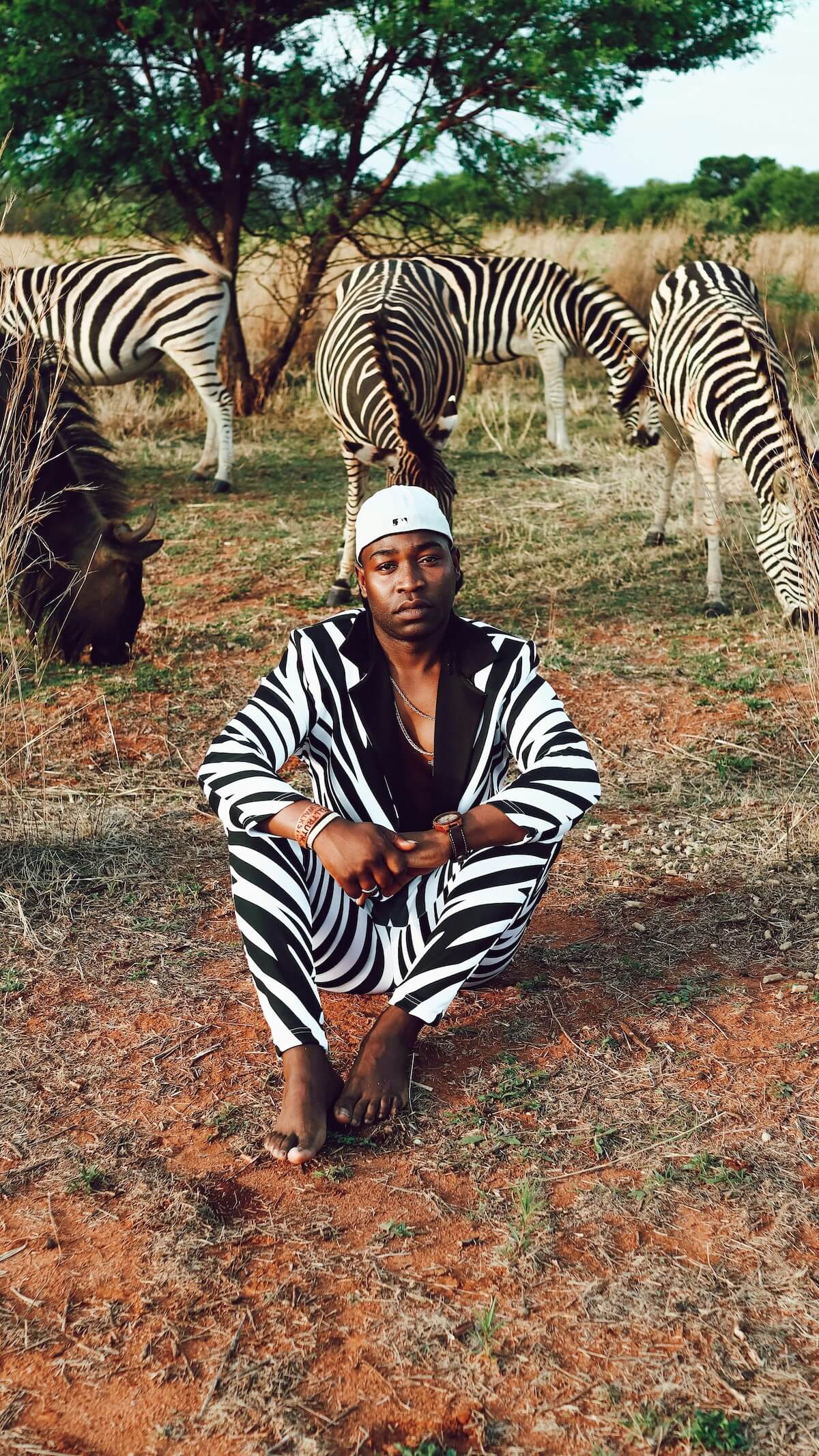 Unsplash: Man wearing zebra print suit with zebras by altin ferreira