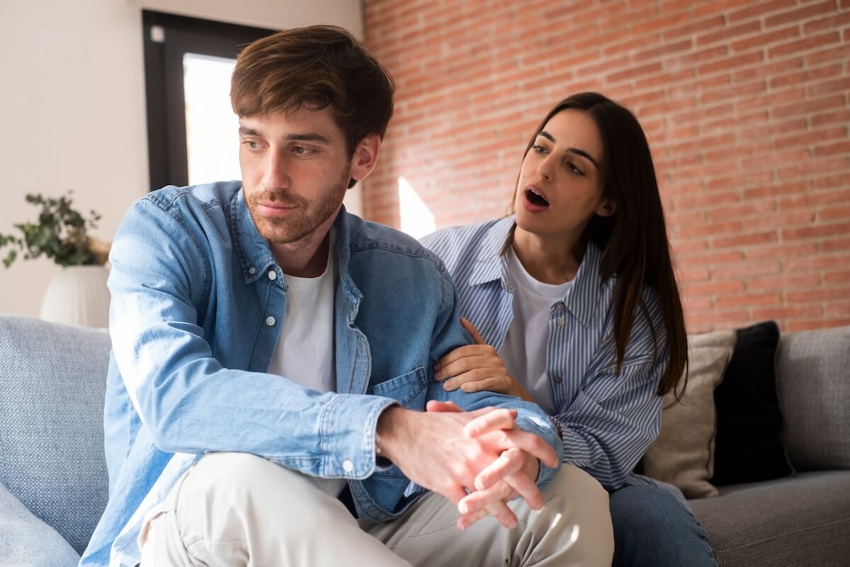 Shutterstock: Sad and angry guy thinking about relationship problems sitting on sofa with offended girlfriend, conflicts in marriage, upset couple after dispute, making decision to break up and divorce