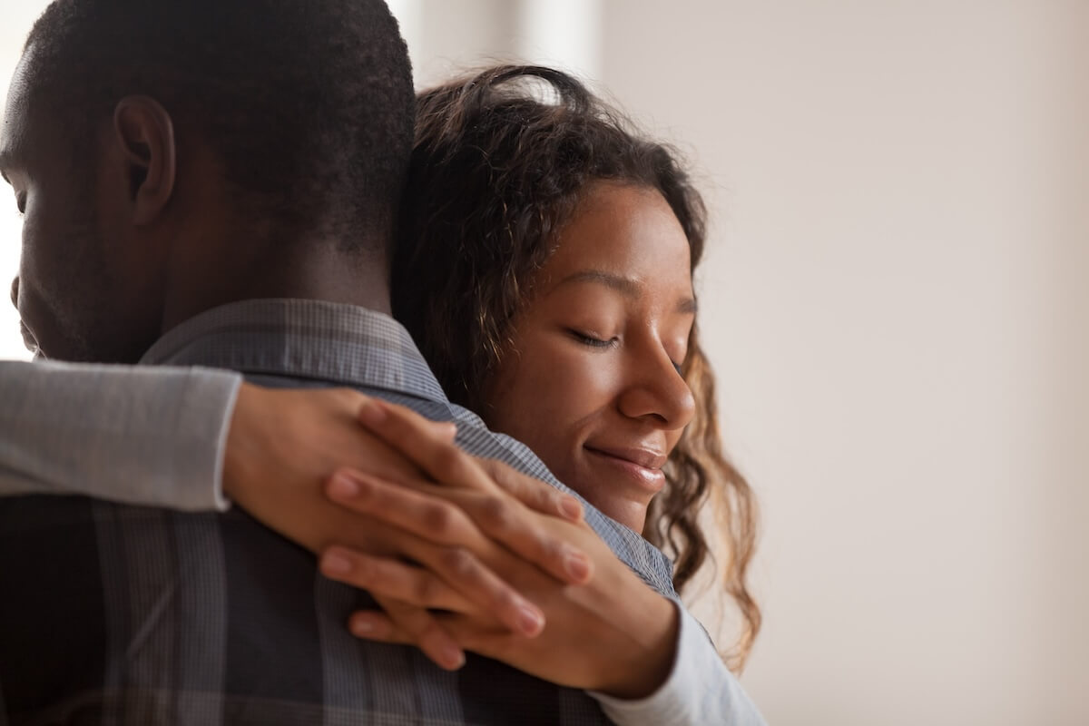 Shutterstock: Close up young black american wife embracing husband. Portrait of woman with closed eyes, man rear view. Attractive affectionate couple in love, romantic relationship support and gratefulness concept