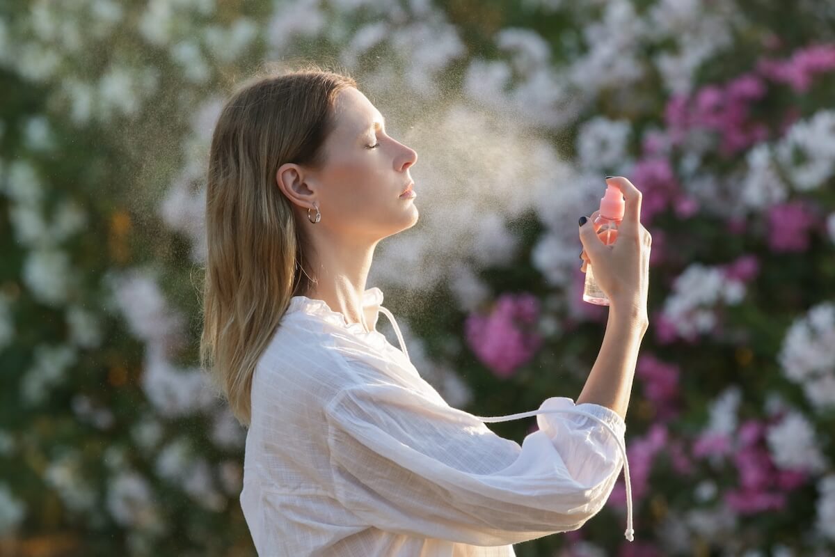 Shutterstock: Woman spraying facial mist on her face, summertime skincare concept