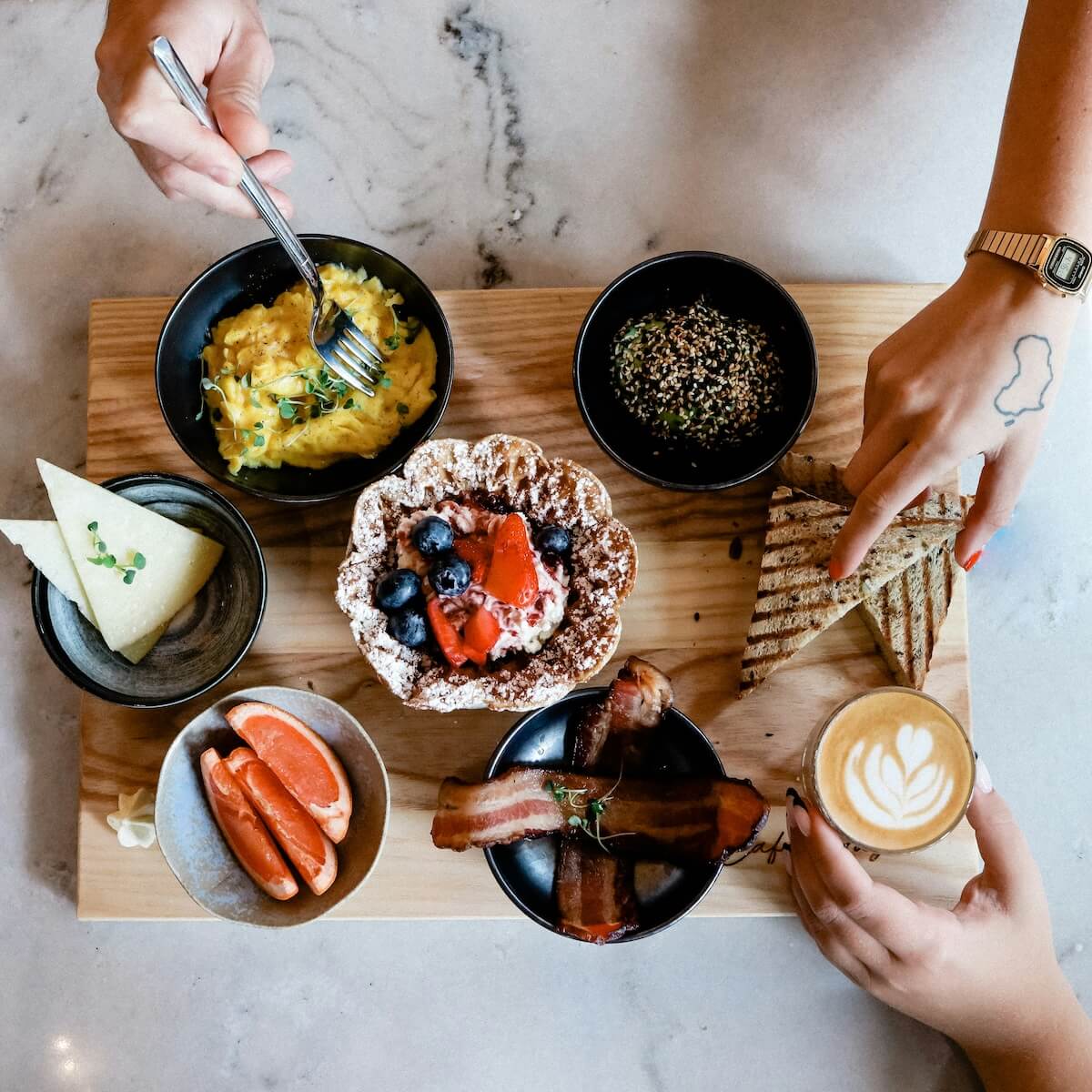 Unsplash: Brunch spread with hands by duncan shaffer