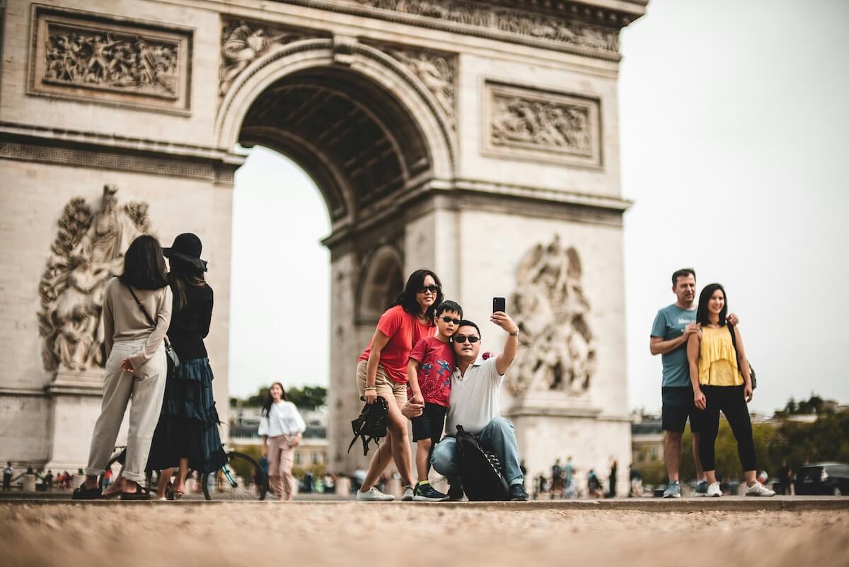 Unsplash: Family taking arc de triomphe selfie in paris, france