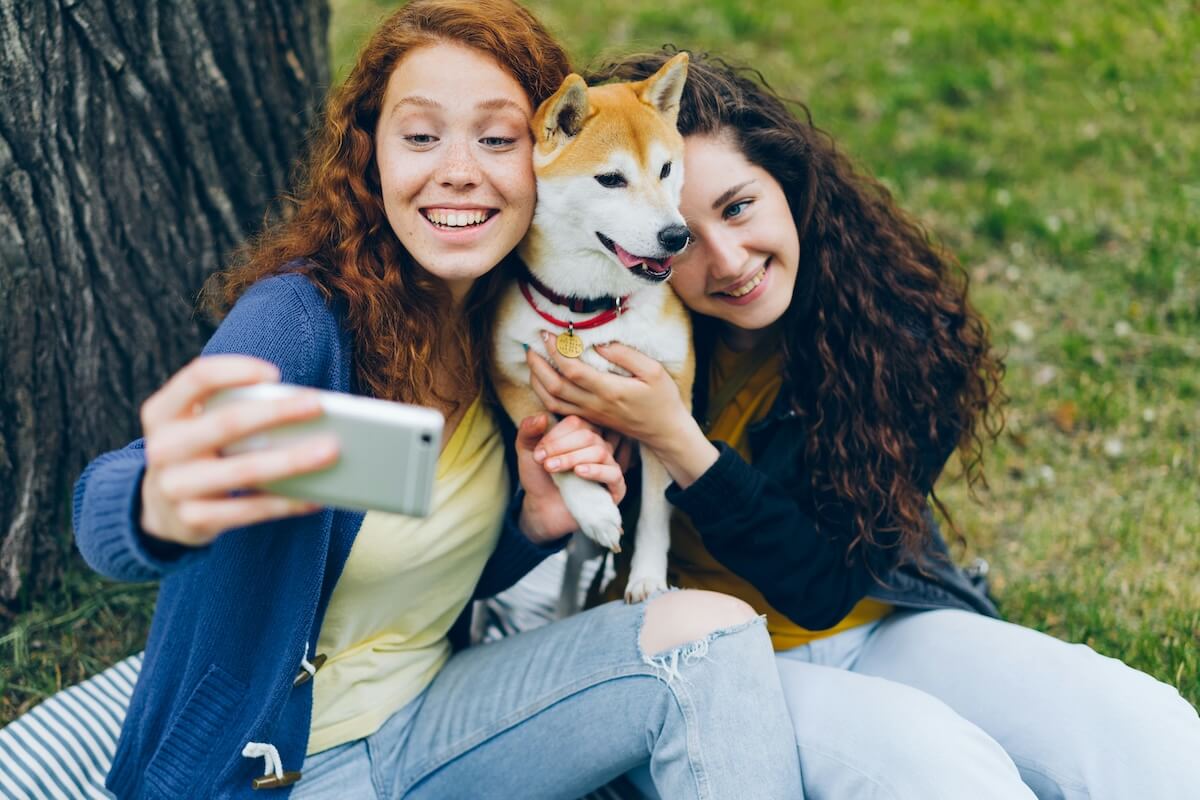 Unsplash: Friends taking selfie with shiba inu dog by Vitaly Gariev