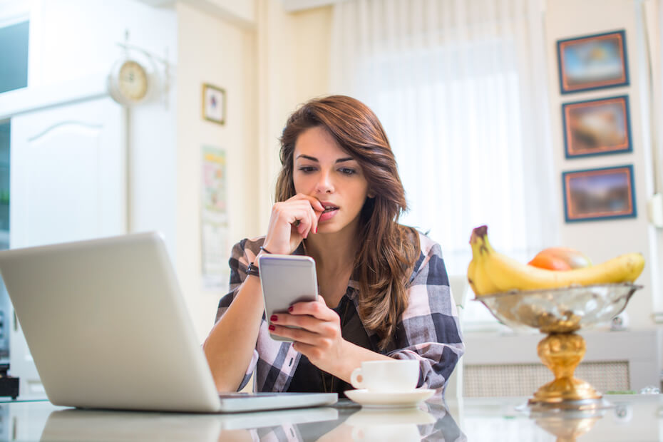 Shutterstock: Woman on phone laptop looking nervous and unahppy