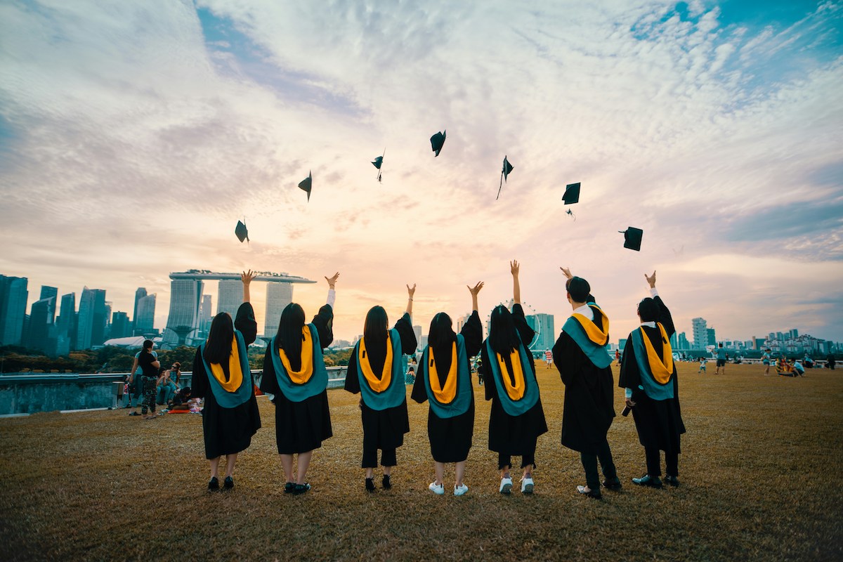 Unsplash: Students throwing graduation caps by Pang Yuhao