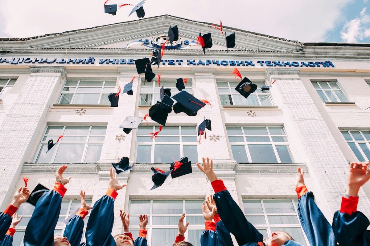 Unsplash: University students throwing graduation caps by Vasily Koloda