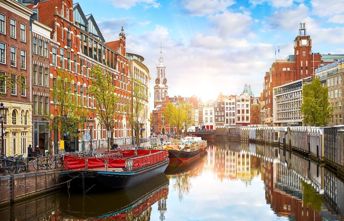 Shutterstock: Channel in Amsterdam Netherlands. Houses and river Amstel. Famous european landmark. Old city landscape during sunset