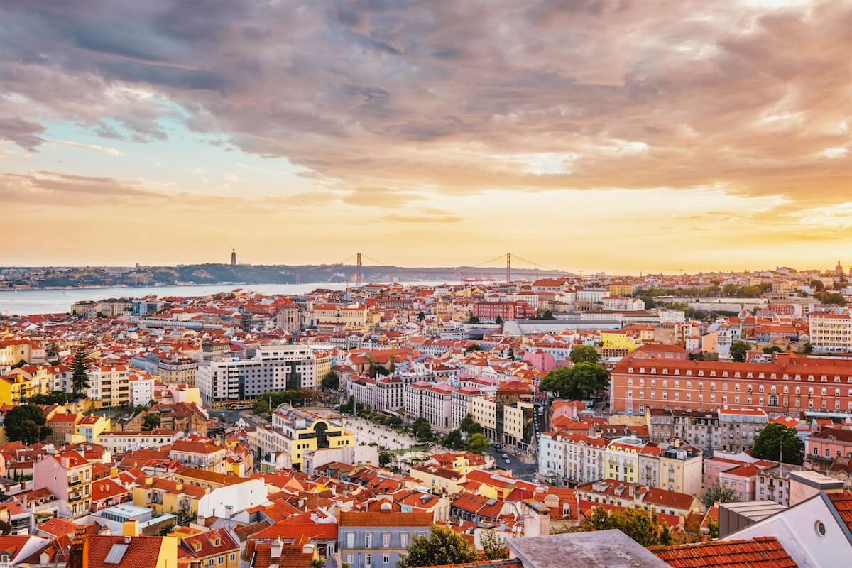 Shutterstock: View of Lisbon famous view from Miradouro da Senhora do Monte tourist viewpoint of Alfama and Mauraria old city district, 25th of April Bridge at sunset. Lisbon, Portugal