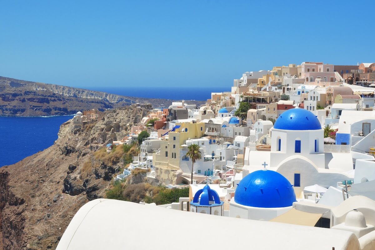 Shutterstock: Oia village on Santorini island, Greece. Traditional and famous church with blue domes and white houses over the Caldera, Cyclades islands Aegean sea.