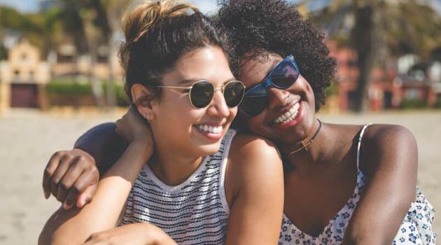 Shutterstock: two friend sitting at the beach together