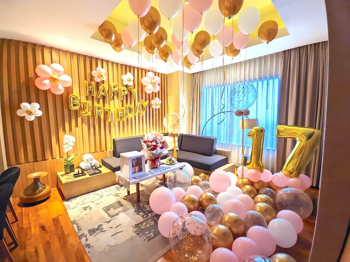 Shutterstock: A beautifully decorated room for a 17th birthday celebration, featuring pink, gold, and white balloons, a 'HAPPY BIRTHDAY' banner, and a large '17' balloon arrangement, creating a festive atmosphere.